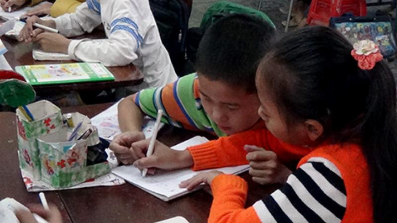 Một học sinh lớp 9 giơ tay phát biểu với vẻ mặt tự tin trong giờ học Ngữ Văn VNEN, thể hiện sự chủ động và hiểu bài